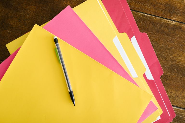 File folders and pen arranged on a  table for office organization.